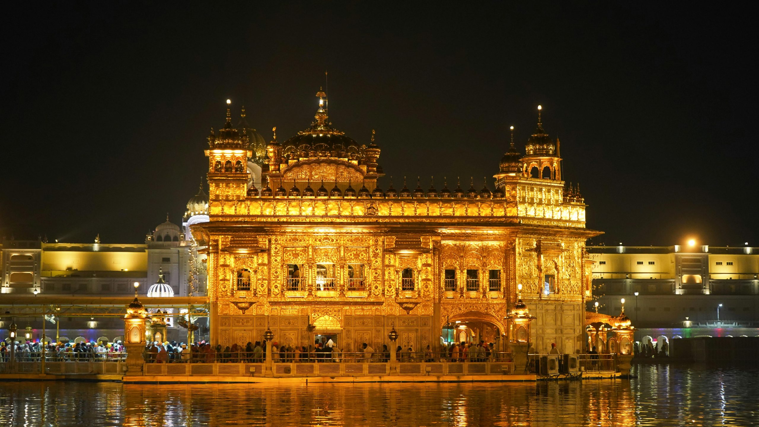 Stunning view of the Golden Temple glowing beautifully at night, reflecting in the serene water.